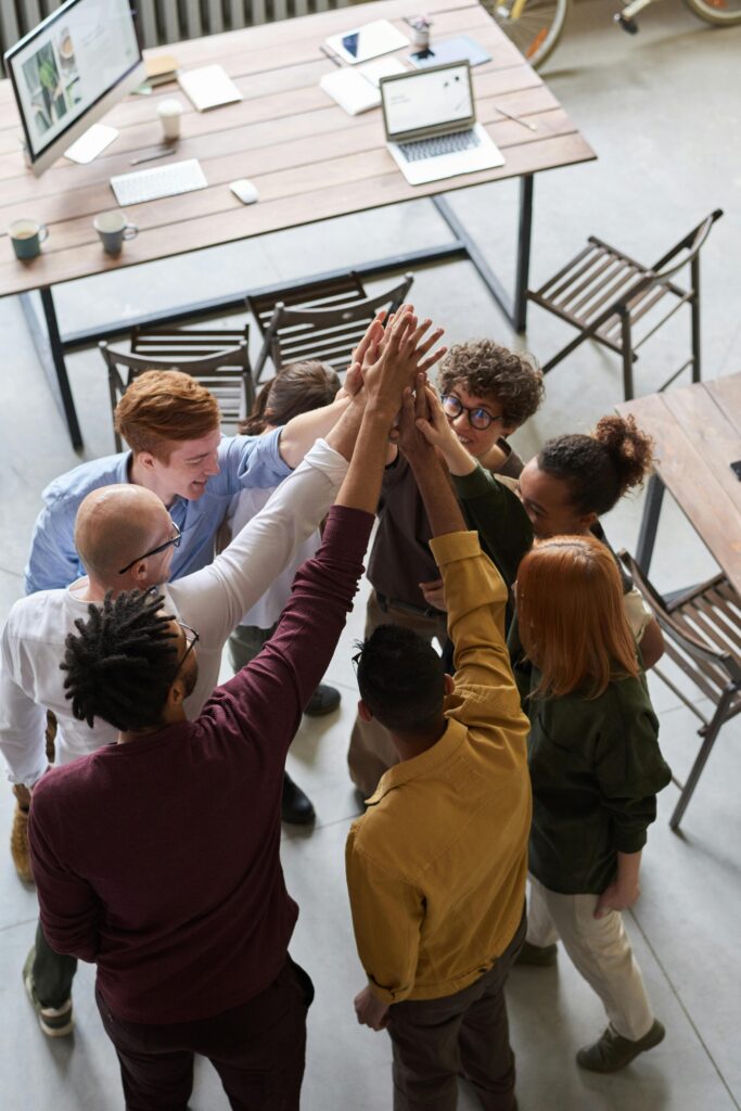 pexels-photo-3184433-3184433 A diverse group of professionals high-fiving in a modern office, showcasing teamwork and collaboration. This team represents our collaborative seo approach